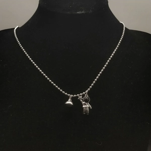 Detail of silver astronaut magnetic couple necklaces on black velvet display