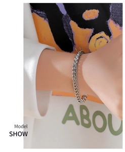 Detail of silver Spiga chain bracelet worn by model with modern orange and white styling