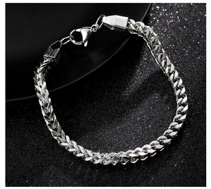 Detailed view of silver braided stainless steel chain bracelet with lobster clasp closure