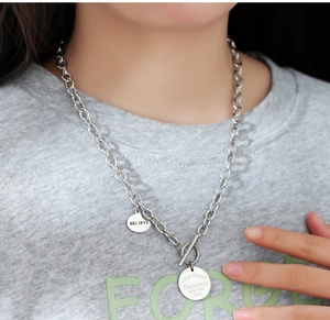 Détail du collier en acier argenté à boucle OT avec doubles pendentifs ronds sur mannequin