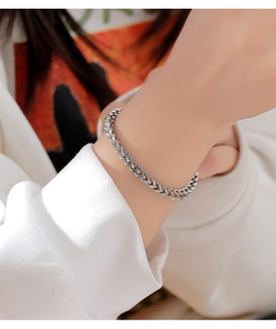 Close-up of minimalist silver wheat chain bracelet worn on a woman's wrist