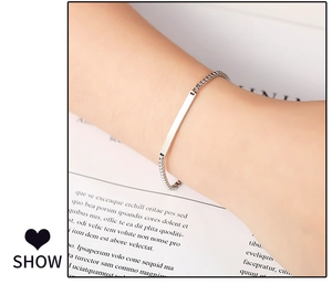 Polished titanium steel curved bar bracelet on wrist with elegant paper background