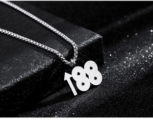 Vue macro du pendentif chiffre 188 sur une chaîne box sur un coffret cadeau noir