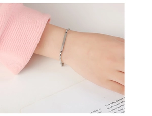 Macro shot of minimalist silver titanium steel ID bracelet with square box chain