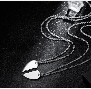 Detailed macro view of polished heart-shaped puzzle necklaces on a black textured surface