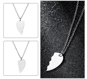 Macro detail of puzzle-shaped polished stainless steel heart pendants for couples