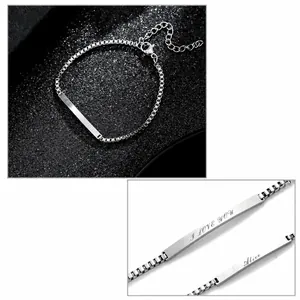 Macro detail of custom engraved I LOVE YOU text on stainless steel bar box chain bracelet