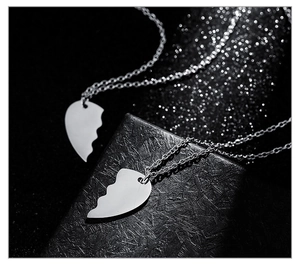 Macro view of polished stainless steel puzzle heart pendants on a black jewelry box