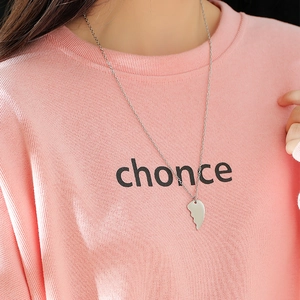 Minimalist stainless steel half-heart puzzle pendant necklace worn by a model