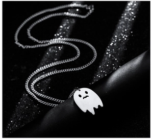 Macro shot of polished silver ghost pendant with wavy bottom on black background