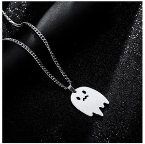Close-up of silver stainless steel shy ghost necklace pendant on black textured surface