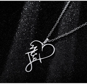Macro shot of silver titanium heart pendant necklace with custom script signature detail