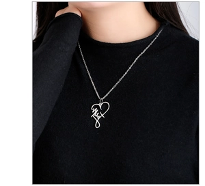 Close-up of heart-shaped titanium steel necklace with artistic script engraving