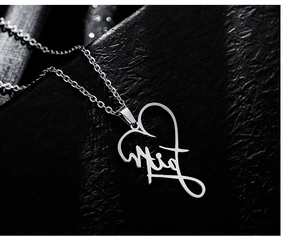 Macro detail of silver heart pendant featuring artistic Faith engraving on chain