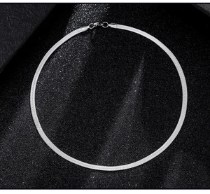 Polished silver flat snake bone chain with lobster clasp on a sparkling black background