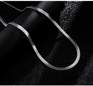 Macro shot of polished silver flat herringbone chain with scale-like metal texture
