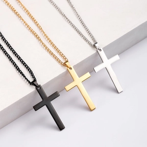 Minimalist cross pendants in matte black, polished gold and silver on white podiums