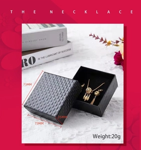 Detail view of 73x73x35mm black diamond pattern jewelry box with gold necklace