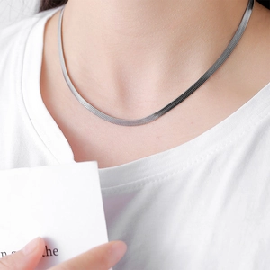 Minimalist silver herringbone snake chain necklace with mirror polish on white t-shirt