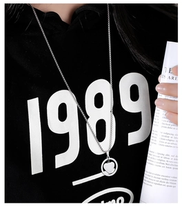 Close-up of heart-shaped cutout pendant necklace styled on a black casual hoodie