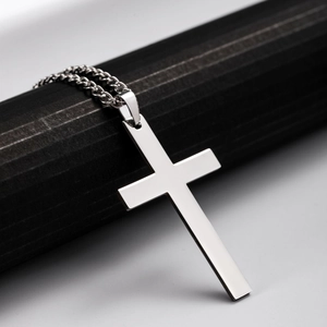 Macro shot of polished stainless steel cross pendant with sleek silver metallic finish