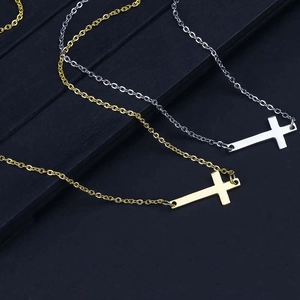 Detailansicht horizontaler Kreuzanhänger in Gold und Silber an feinen Halsketten