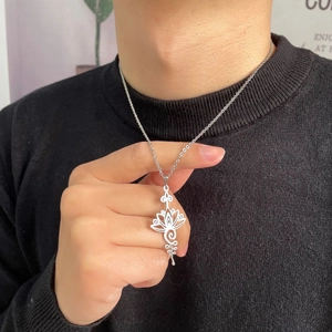 Collier avec pendentif mandala lotus en acier inoxydable argenté sur un pull en maille noir