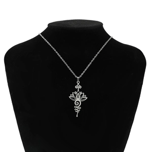 Élégant collier pendentif lotus unalome en acier inoxydable sur support à bijoux noir