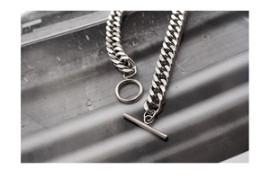 Detailed close-up of heavy silver cuban curb chain with industrial OT toggle clasp design