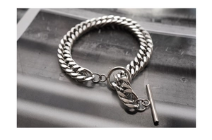Close-up of silver Cuban link chain bracelet with decorative T-bar toggle clasp