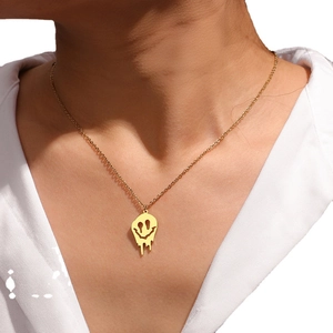 Halskette aus goldfarbenem Titanstahl mit schmelzendem Smiley-Anhänger am Model