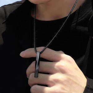 Macro shot of men's matte black twisted bar pendant on a sleek bead chain necklace