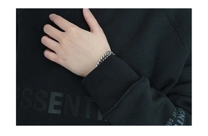 Close-up of polished silver Cuban link bracelet with OT toggle clasp on wrist