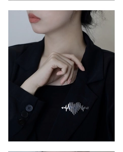 Silver heart and heartbeat brooch with Cupid arrow on a black blazer lapel