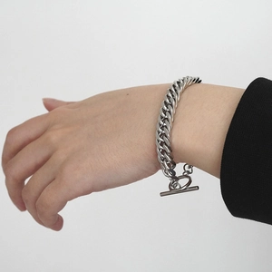 Silver Cuban link bracelet with OT toggle clasp worn by model on black sleeve