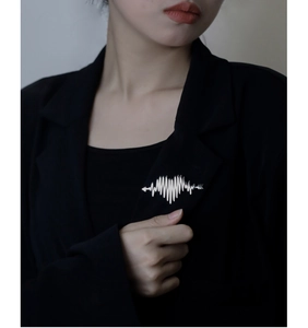 Close-up of heart-shaped heartbeat brooch pinned on a black suit blazer lapel