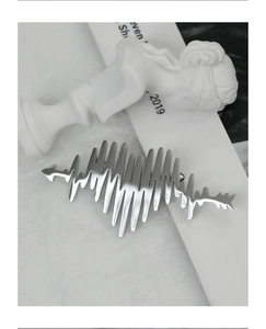 Macro shot of silver heartbeat waveform brooch on a minimalist artistic background
