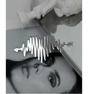 Artistic detail of a silver heartbeat ECG brooch with wave pattern and arrow accents