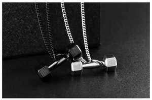 Detailed close-up of dumbbell pendants with inspirational engraving in black and silver