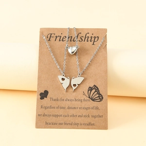 Détail de colliers d'amitié papillon magnétiques sur une carte cadeau kraft