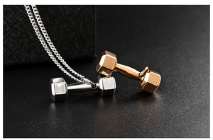 Macro view of polished dumbbell pendants in silver and rose gold with engraved inscriptions