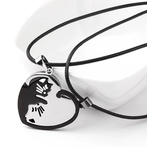 Macro view of interlocking cat heart pendants in polished black and silver stainless steel