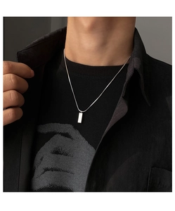 Vue macro d'un collier pendentif rectangulaire en argent poli sur une chaîne fine