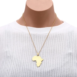 Close-up of golden Africa map pendant necklace on model wearing white knitwear