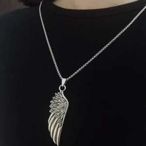 Détail du collier pendentif aile en plumes vintage avec texture fine sur un mannequin