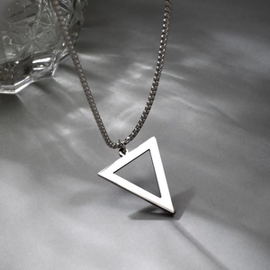 Vue détaillée d'un collier en acier inoxydable argenté avec pendentif triangle poli