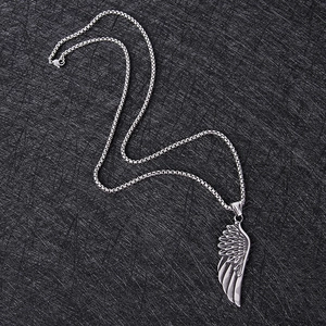 Gros plan détaillé du pendentif aile d'ange en argent rétro sur chaîne maille ronde