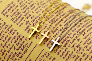 Detailed macro view of mini cross necklaces in gold, silver, and rose gold finishes