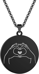 Close-up of black matte circular pendant with engraved heart gesture on round link chain