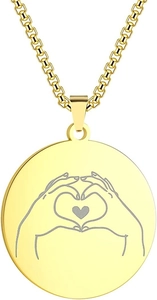 Detailed macro view of gold stainless steel round pendant with hand heart engraving